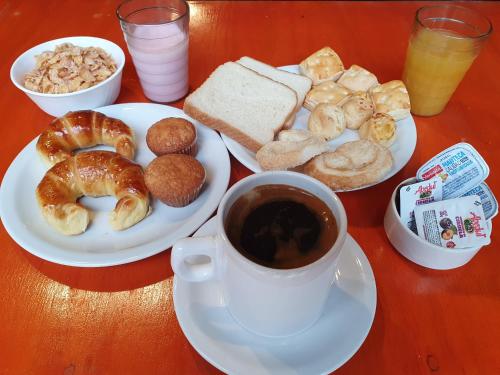 a table with a plate of donuts and a cup of coffee at Hotel AATRAC Iguazú in Puerto Iguazú