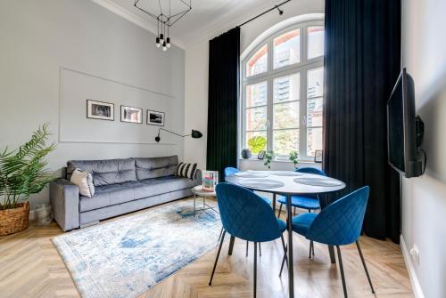 a living room with a couch and a table and chairs at Dom & House - Apartments Waterlane Vintage in Gdańsk