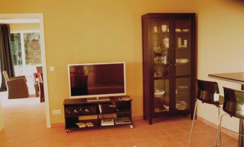 a living room with a flat screen tv and a entertainment center at Mamsahi in Friedenstal