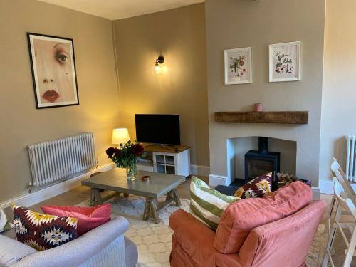 a living room with two couches and a fireplace at Relaxing cottage in the beautiful Usk Valley in Usk