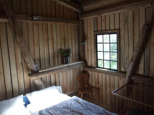 ein Schlafzimmer mit einem Bett in einer Holzhütte in der Unterkunft Scheune in Kirch Mulsow