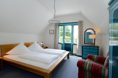 Schlafzimmer mit einem Bett und einem Fenster in der Unterkunft Haus Poggfred Whg 06 Swan in Wyk auf Föhr
