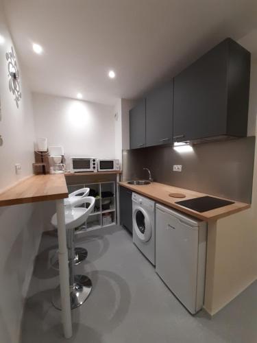 - une cuisine avec une table et un lave-linge/sèche-linge dans l'établissement Les Prairies de Bellevue, idéal curistes, vacanciers et ouvriers, à La Roche-Posay