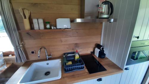 a kitchen with a sink and a counter with a sink at Roulotte les Mésanges in Rebecq-Rognon