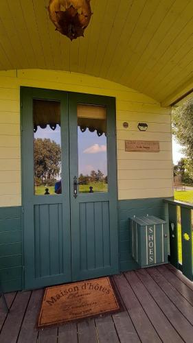 a front door of a house with two windows at Roulotte les Mésanges in Rebecq-Rognon