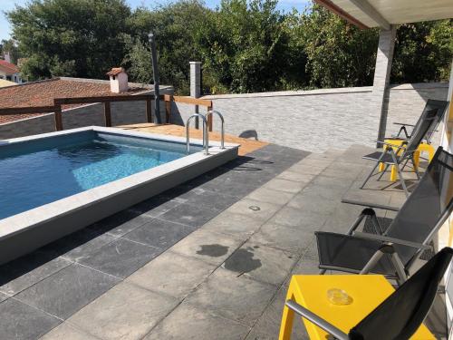 a pool on a patio with chairs and a table at Sun house - Near Sintra - Kitchen - Pool in Sintra