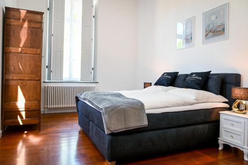 - une chambre avec un lit et un canapé bleu dans l'établissement Römer-Apartment im Herenhaus Rheinblick, à Xanten
