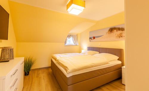 1 dormitorio con 1 cama en una habitación amarilla en Seeadler - a26427 en Zingst