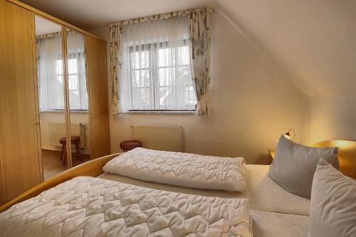 a bedroom with a large bed and two windows at Zähler, Brunhilde in Zingst