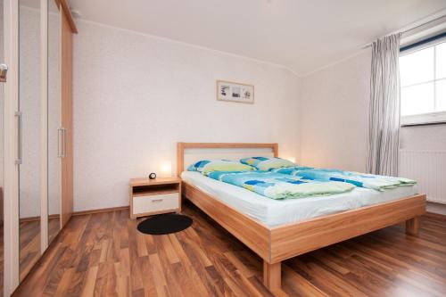 una camera con letto e pavimento in legno di Wohnung 2 a Fehmarn
