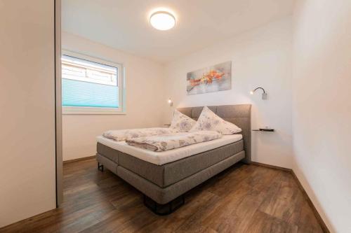 ein Schlafzimmer mit einem Bett in einem Zimmer mit einem Fenster in der Unterkunft Apartment Jasmin in Neustift im Stubaital