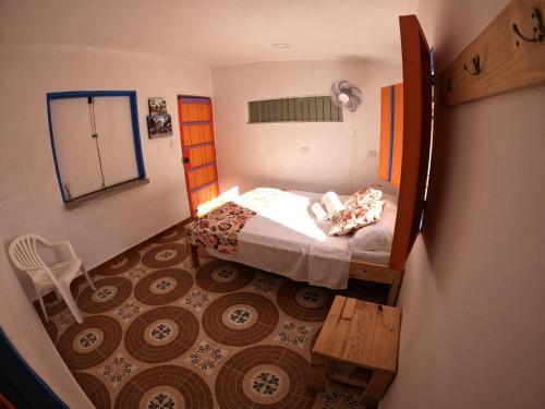a small bedroom with a bed and a chair at Finca Hotel Estrella del Eden in Armenia
