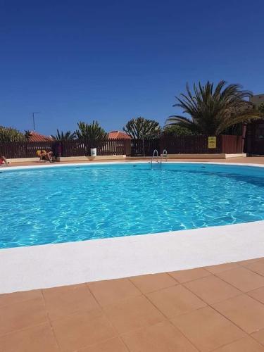 a large swimming pool with blue water at Casa Castillo in Caleta De Fuste