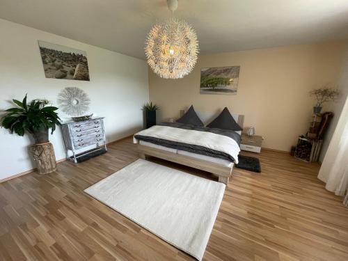 a bedroom with a bed and a chandelier at Adonde in Neuried