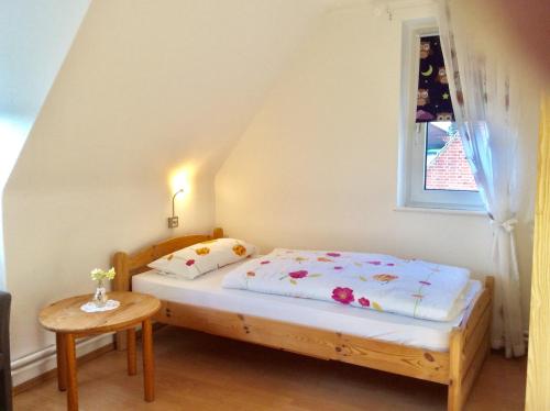 um pequeno quarto com uma cama e uma mesa em Neue Straße 3 em Grossenbrode