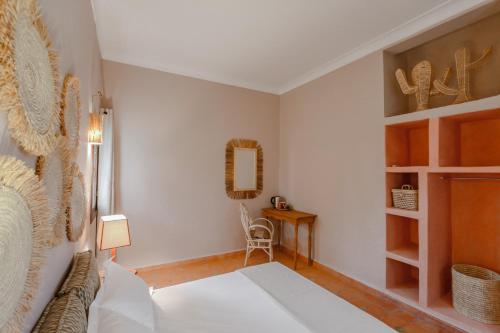 a bedroom with a bed and a table and a chair at Upupa de l’Atlas in Marrakech