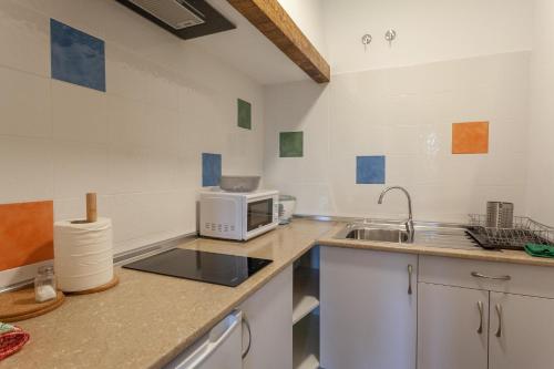 a kitchen with a microwave and a sink at El Albergue de Sigüenza in Sigüenza