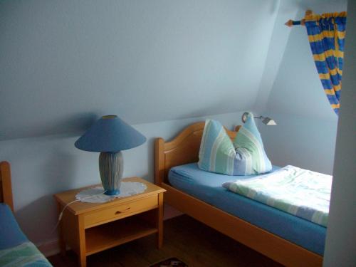 ハイリゲンハーフェンにあるFerienwohnung mit Ostseeblickの小さなベッドルーム(ベッド1台、ナイトスタンドのランプ付)