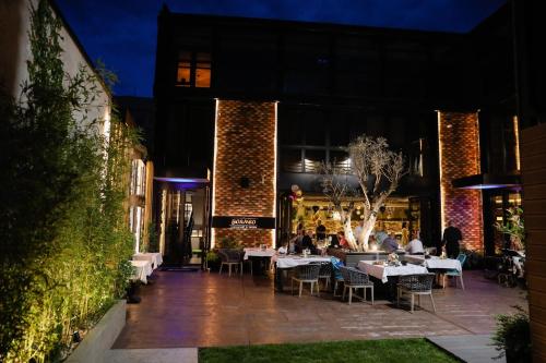 a restaurant with tables and people sitting at tables at Hotel Borneo in Pančevo