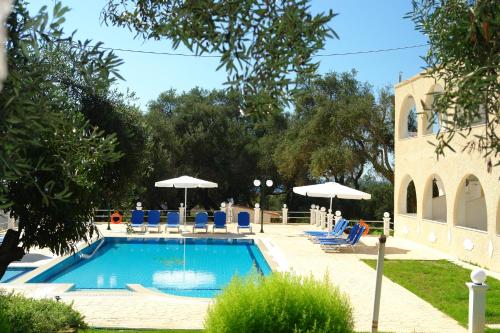 a swimming pool with chairs and umbrellas at Prasoudopetra in Ágios Matthaíos