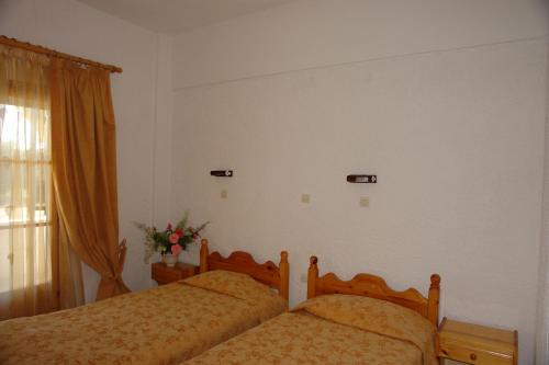 a bedroom with two beds and a window at Prasoudopetra in Ágios Matthaíos