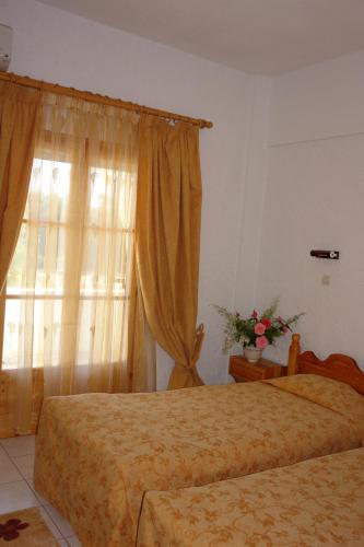 a hotel room with two beds and a window at Prasoudopetra in Ágios Matthaíos