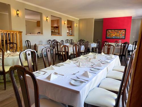 a dining room with white tables and chairs at The Historic Hogsback Inn in Hogsback