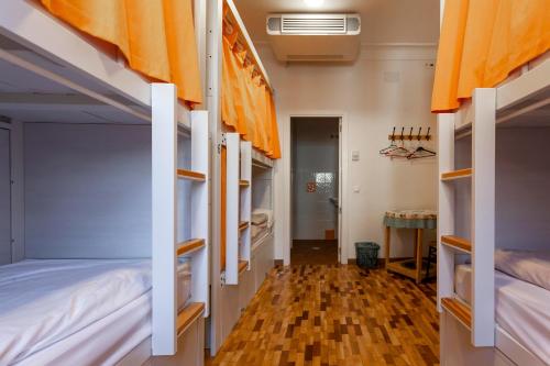 a room with three bunk beds and a hallway at El Albergue de Sigüenza in Sigüenza