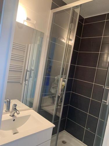 une salle de bain avec une douche, un lavabo et un miroir dans l'établissement Vacances Cap Esterel Apartment - Agay, à Agay