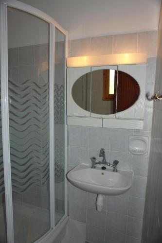 a bathroom with a sink and a shower with a mirror at Prasoudopetra in Ágios Matthaíos