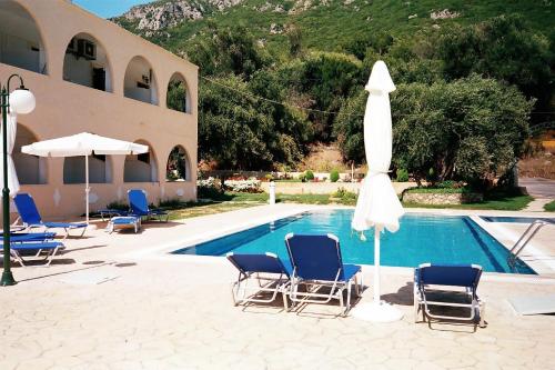 a swimming pool with chairs and a umbrella and a pool at Prasoudopetra in Ágios Matthaíos