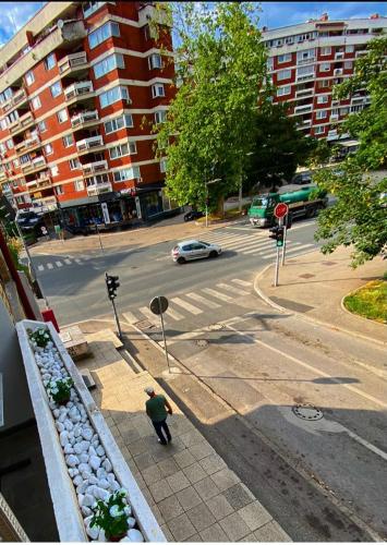 a person standing on a sidewalk near a street at Apartman OMAR stan na dan besplatan parking Sarajevo in Sarajevo