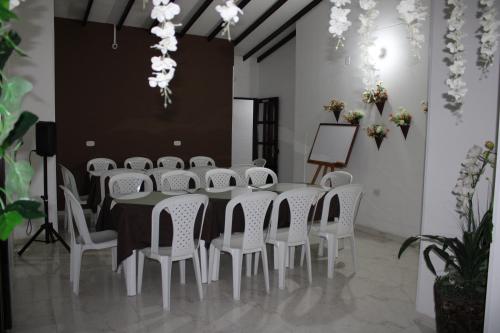 a conference room with a table and white chairs at Hotel Marialu in Ocaña