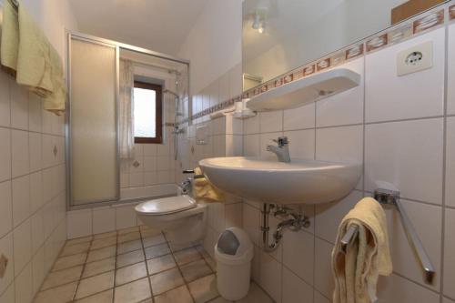 een witte badkamer met een wastafel en een toilet bij Schleswig-Holstein Whg 01 EG li in Nieblum
