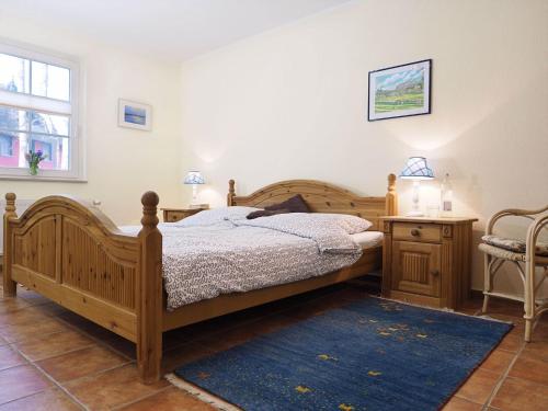 a bedroom with a wooden bed and a blue rug at Müggenburger Weg 1 Whg 1 in Zingst