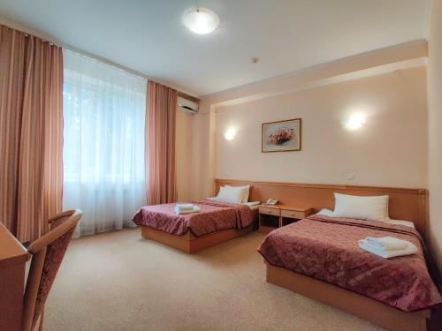 a hotel room with two beds and a window at Заміський комплекс "Пуща Лісна" in Moshchun