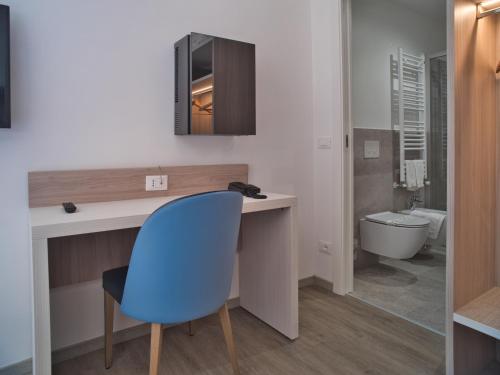 a bathroom with a desk and a blue chair at Hotel Medusa in Finale Ligure
