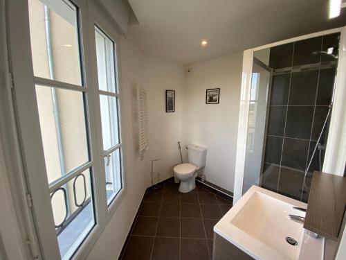 une salle de bain avec toilettes, lavabo et fenêtre dans l'établissement T4 Disney Paris/Val d’Europe, à Serris