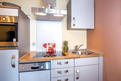 a small kitchen with white cabinets and a sink at ancora Marina Haus 2 Nr 03, Typ 2 in Neustadt in Holstein