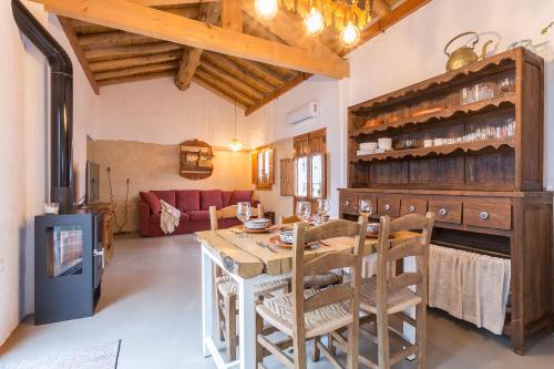 een keuken met een tafel en stoelen en een woonkamer bij Encantadora casa rural con piscina privada in El Bosque