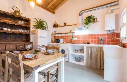 cocina con mesa de madera y fregadero en Encantadora casa rural con piscina privada, en El Bosque