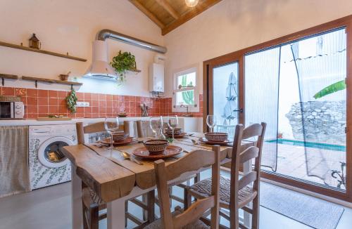 cocina con mesa de madera con sillas y fregadero en Encantadora casa rural con piscina privada en El Bosque