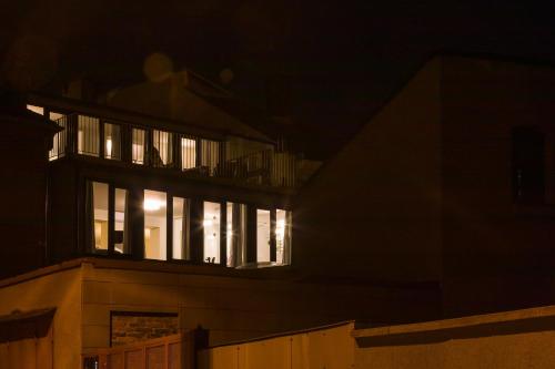 a building with lit up windows at night at Hotel & Gallery Kopacka in Svitavy