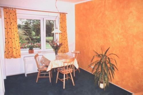 een eetkamer met een tafel en stoelen en een raam bij Windspiel, FW 2 in Zingst
