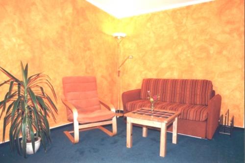 een woonkamer met een bank, een stoel en een tafel bij Windspiel, FW 2 in Zingst