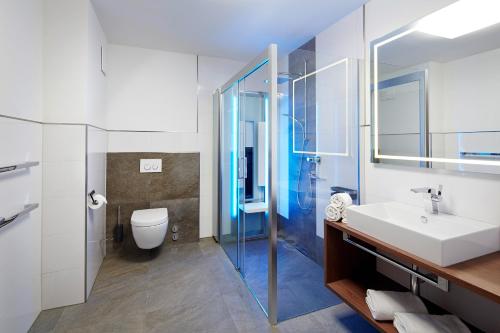 ein Badezimmer mit einem Waschbecken, einem WC und einem Spiegel in der Unterkunft Apartment S in Ehrwald