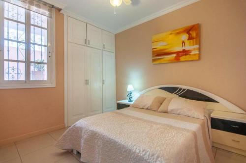 a bedroom with a bed and a painting on the wall at Apartament 1 bedroom Los Cristianos Las Vistas beach in Los Cristianos