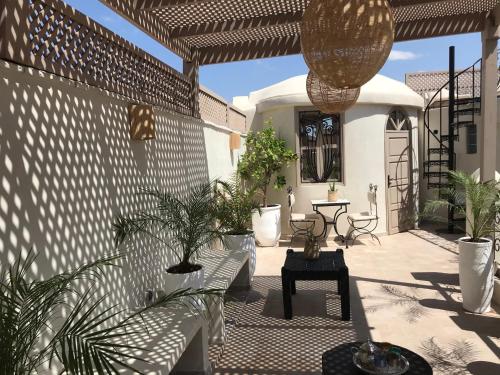a patio area with a patio table and chairs at Riad Dollar Des Sables & Spa in Marrakesh