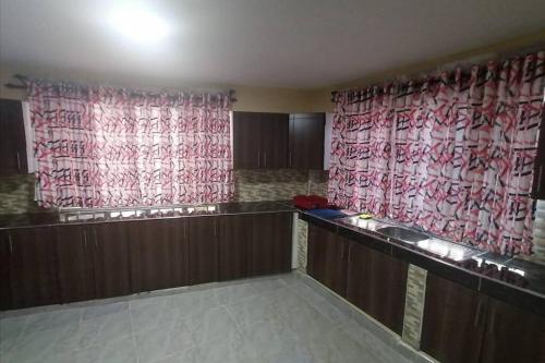 una sala de espera con cortinas rojas y blancas en Lass Grove Home, en Kisii