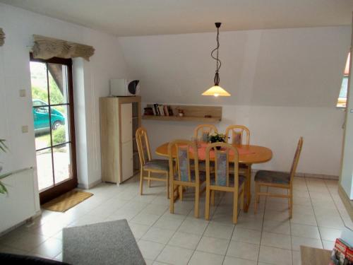 - une cuisine et une salle à manger avec une table et des chaises dans l'établissement Finnhäuser am Vogelpark - Haus Annika, à Marlow